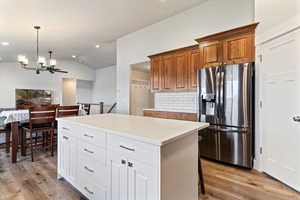 Well-designed kitchen with quartz countertops, subway tile backsplash, two-tone knotty alder cabinets, soft-close drawers, upgraded lighting, and an oversized pantry with a dedicated prep zone