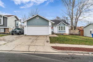 View of front of property with driveway, a garage, and a chimney