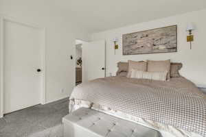 Bedroom featuring carpet and vaulted ceiling