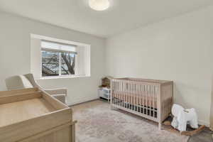 Bedroom featuring a nursery area and baseboards