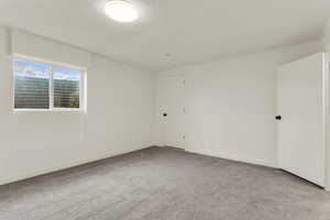 Empty room with light carpet and baseboards