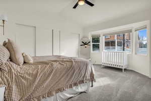 Bedroom with vaulted ceiling, carpet, multiple closets, and ceiling fan