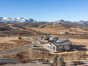 Aerial view of property and surrounding area with a mountain backdrop