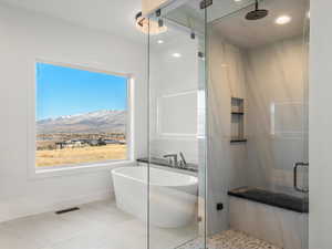 Full bathroom with a soaking tub, a stall shower, recessed lighting, a mountain view, and light tile patterned floors