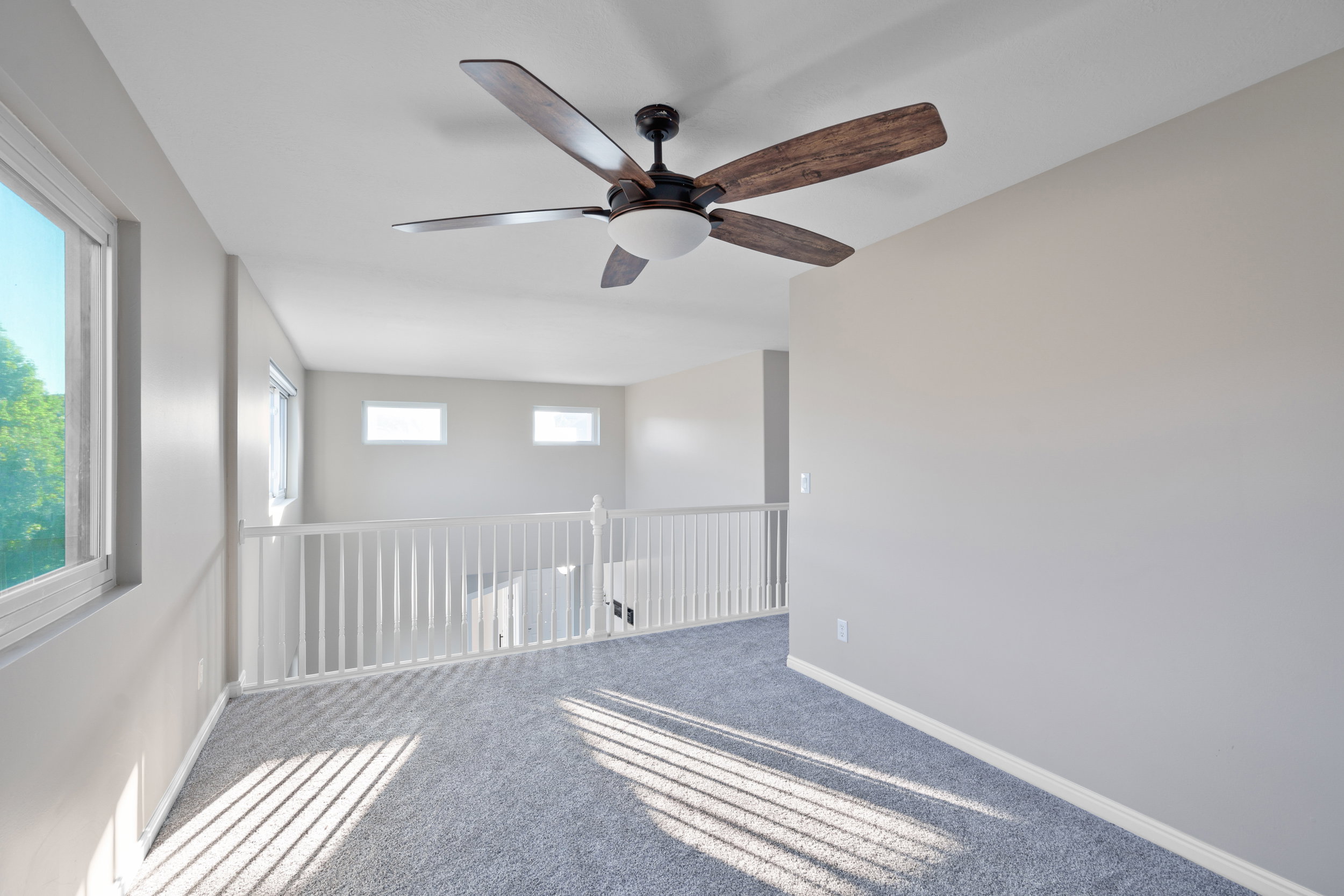 Upstairs loft/Spare room with carpet flooring and ceiling fan