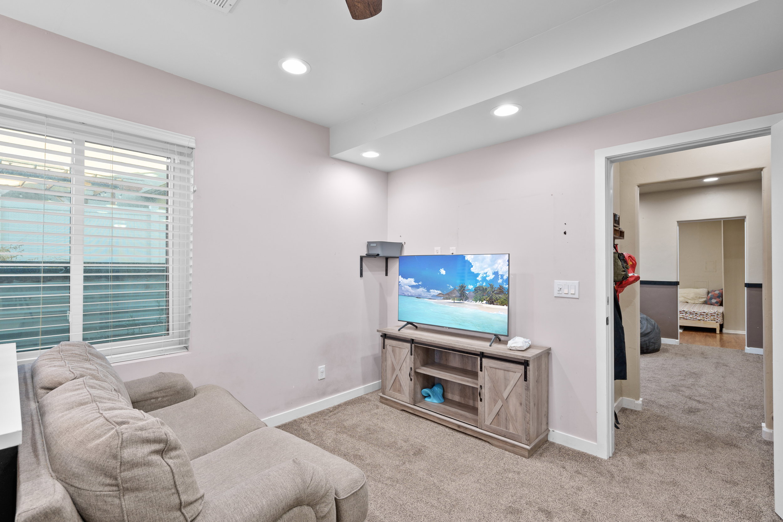 Living area with carpet flooring, a ceiling fan, and recessed lighting