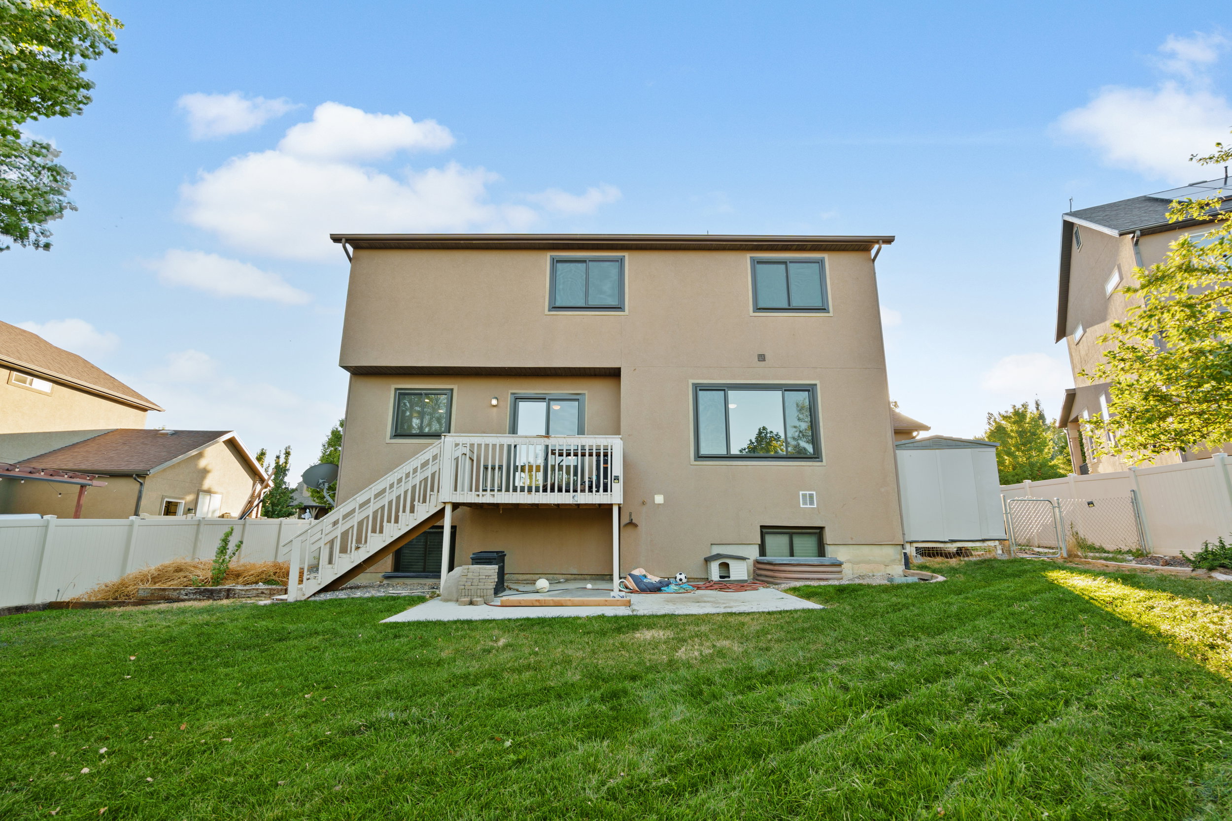 Back of house featuring a patio, a fenced backyard, a deck, stucco siding, and stairway