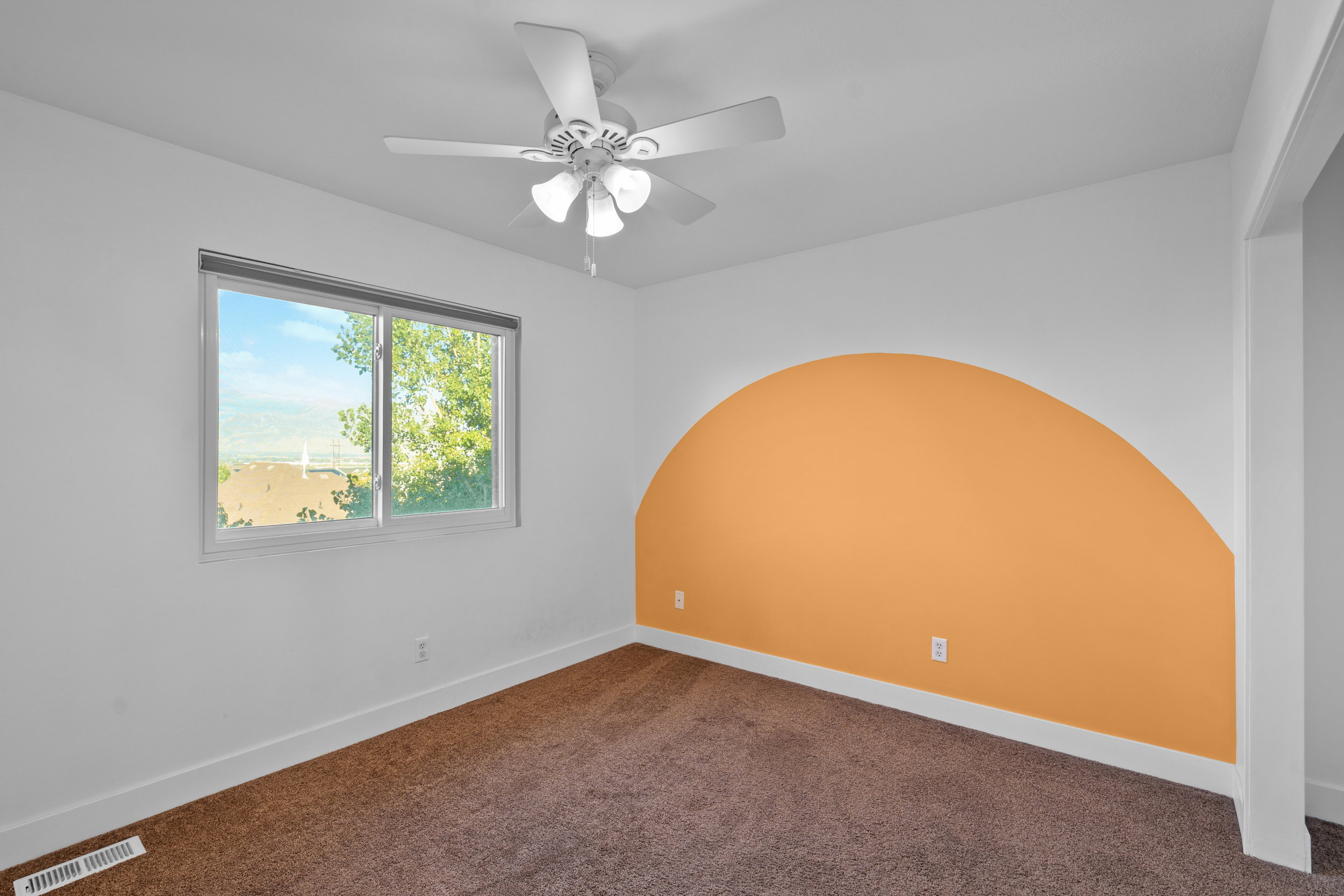 Empty room with dark colored carpet and ceiling fan