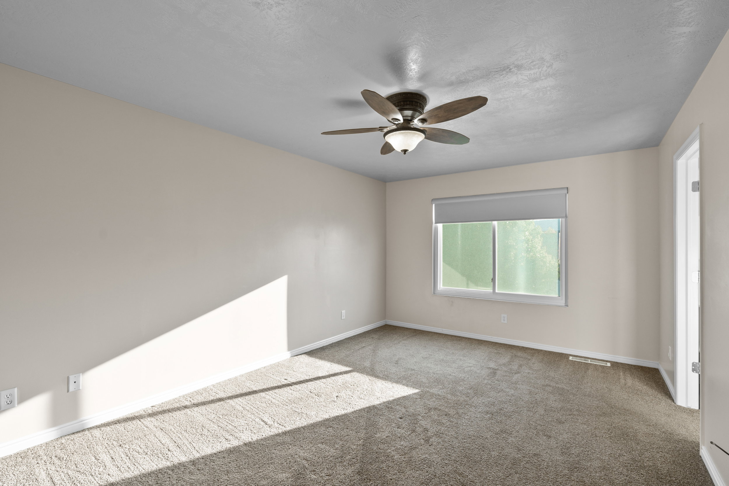 Owners Suite/Master Bedroom Carpeted bedroom featuring a ceiling fan and a textured ceiling