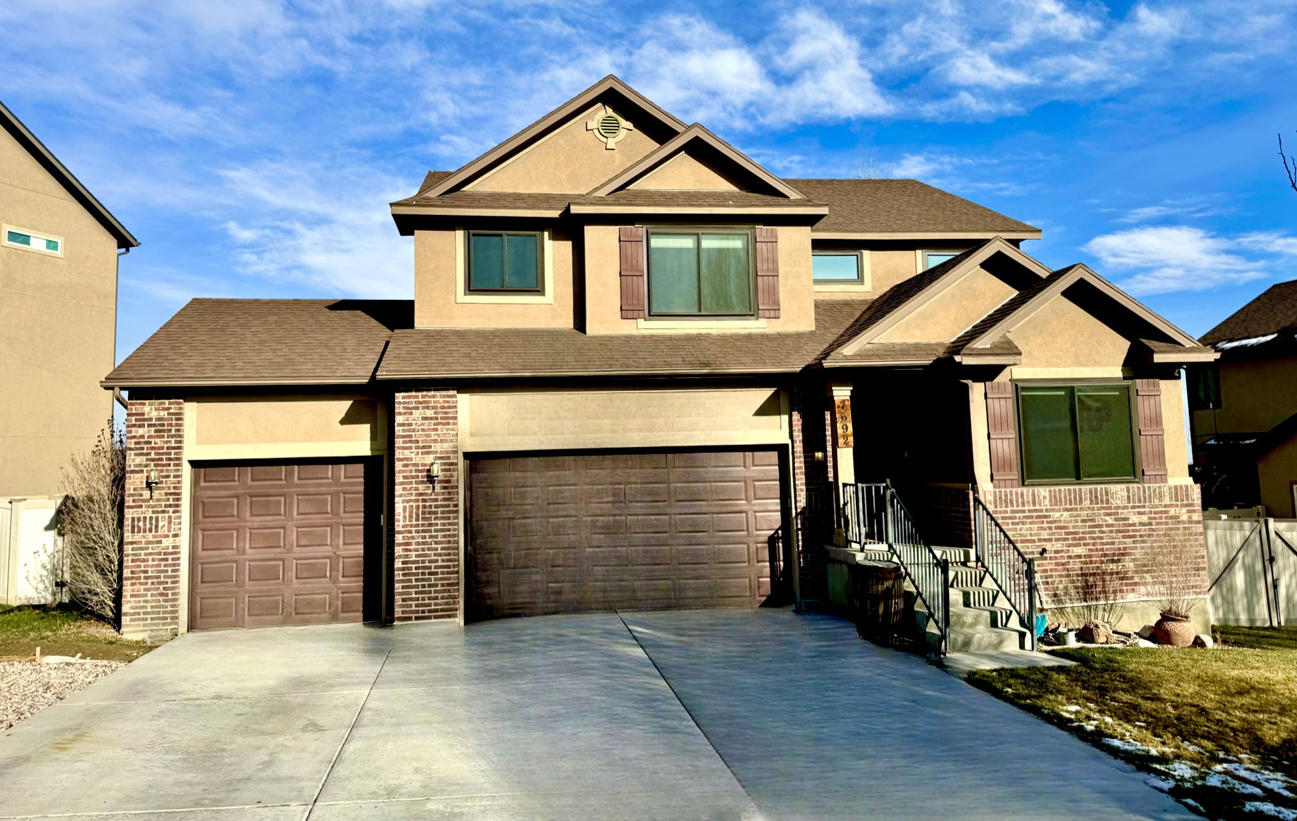 Craftsman-style house with brick siding, concrete driveway, and stucco siding