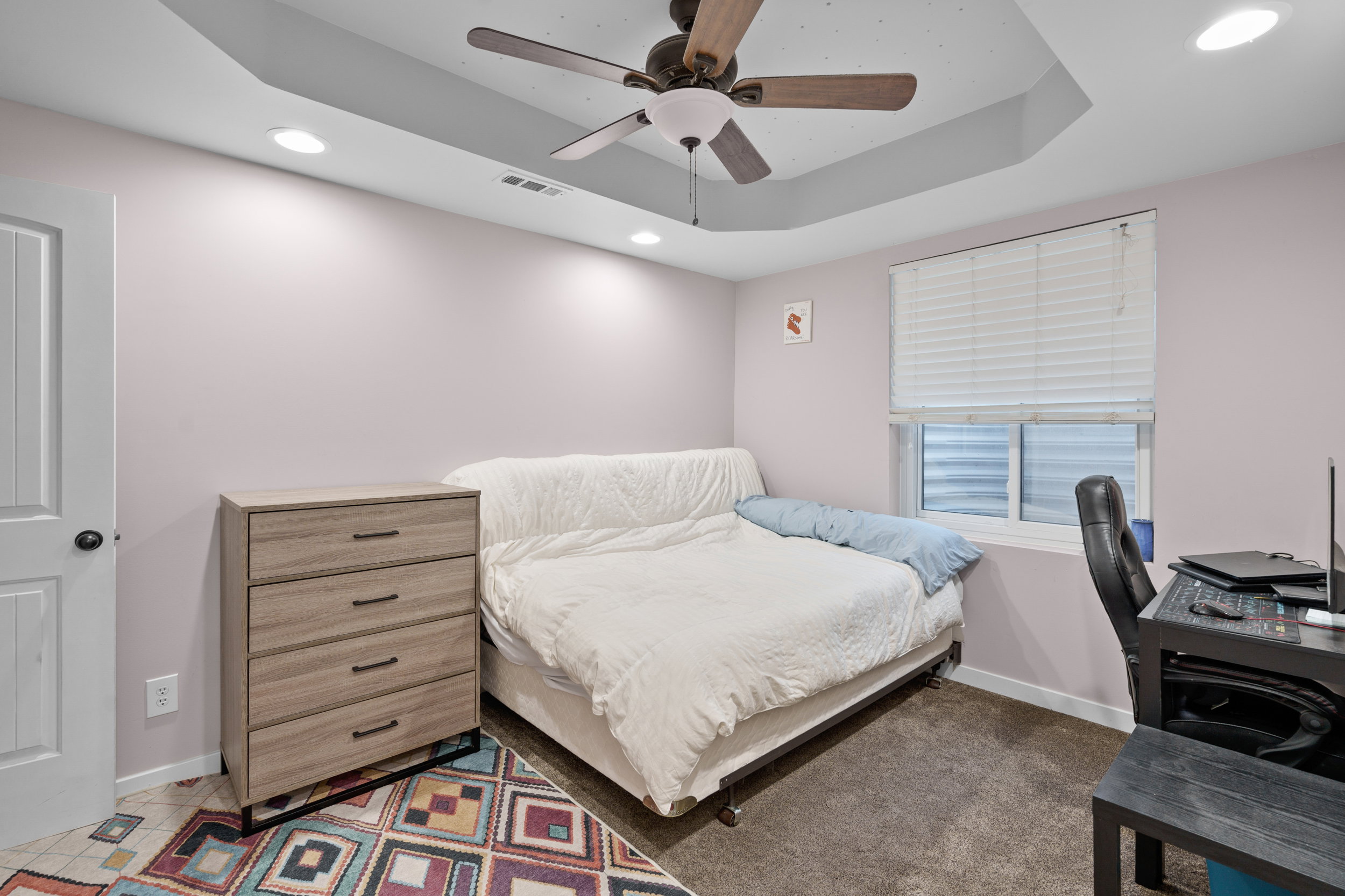 Bedroom with recessed lighting, a raised ceiling, a ceiling fan, and an office area