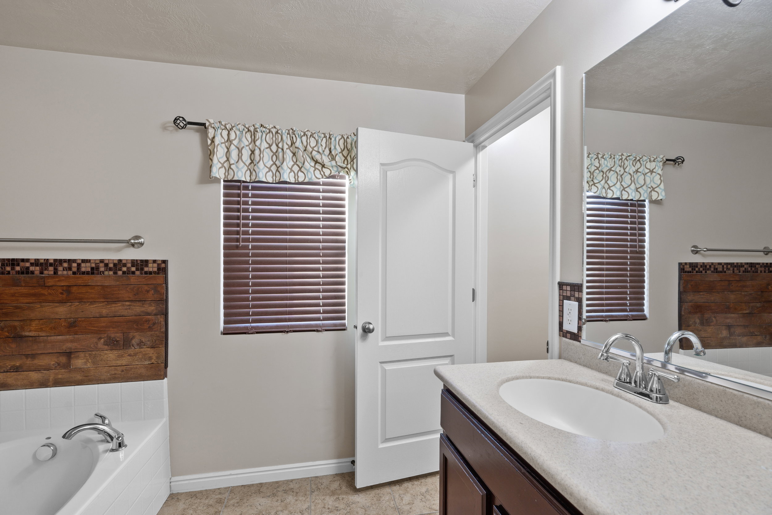 Owners/Master Bathroom featuring a bath, vanity, and a textured ceiling
