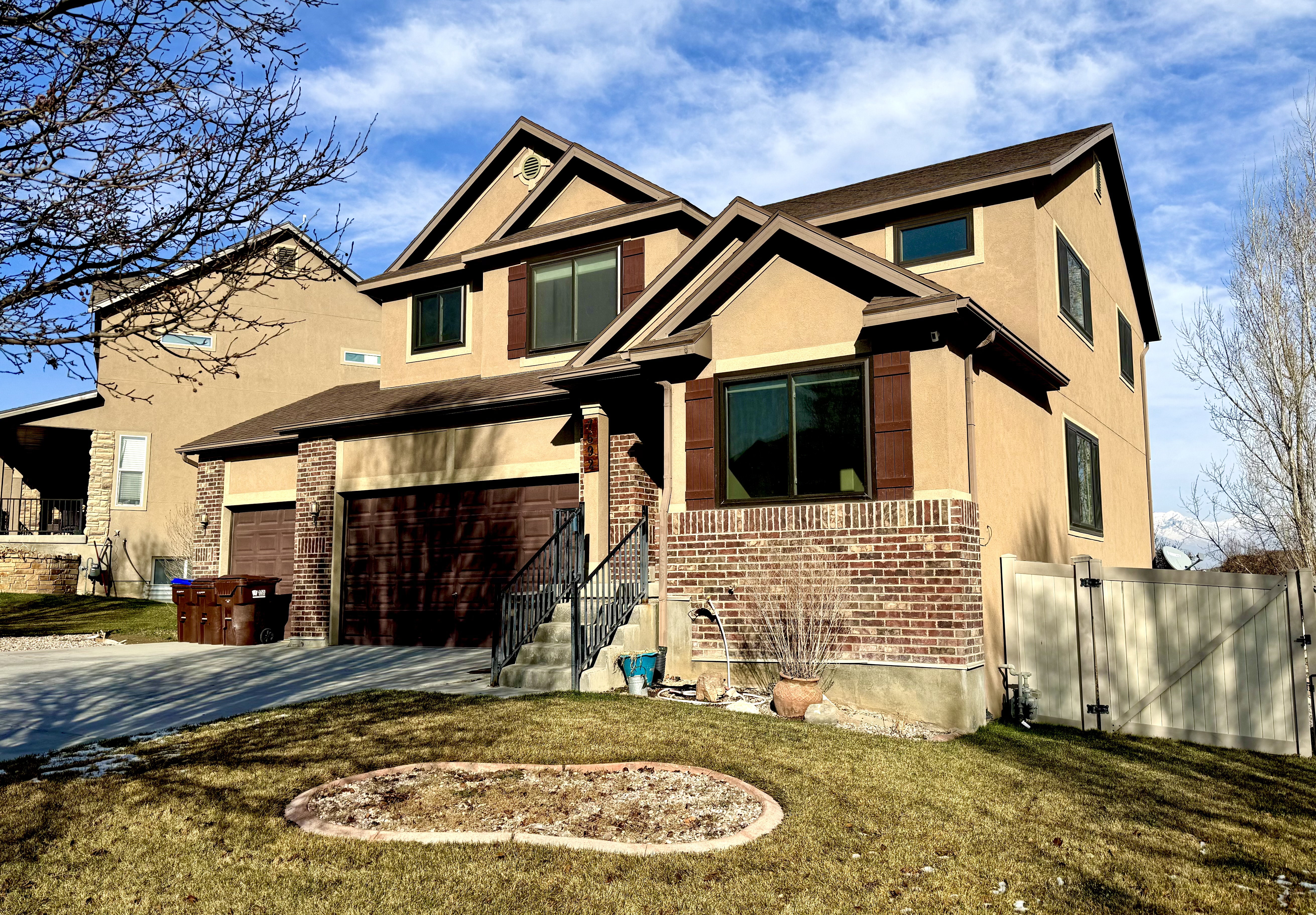 Craftsman inspired home with brick siding, concrete driveway, stucco siding, and a garage
