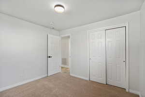 Unfurnished bedroom featuring carpet flooring and a closet