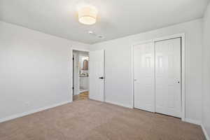 Unfurnished bedroom featuring light colored carpet and a closet