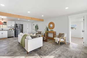 Living area with recessed lighting, light wood-type flooring, and beam ceiling