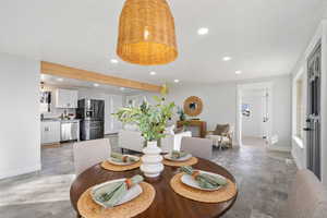Dining room featuring recessed lighting, light wood finished floors, and beamed ceiling