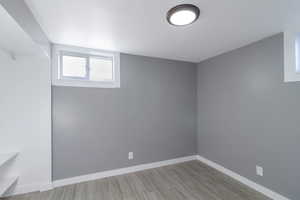 Spare room with baseboards and wood finish floors