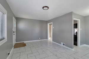 Unfurnished room featuring baseboards and light marble finish floors
