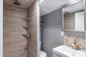 Full bath featuring vanity and a tile shower