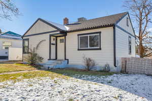 Bungalow with board and batten siding, a shingled roof, and a chimney