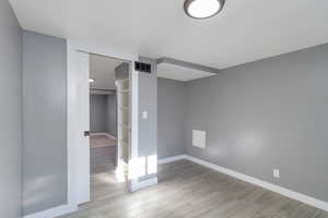 Unfurnished bedroom featuring a walk in closet and wood tiled floors
