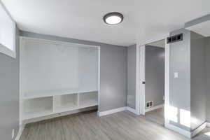 Unfurnished bedroom featuring wood tiled floors and a closet