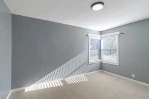 Carpeted spare room with baseboards