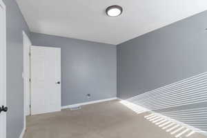 Empty room with carpet flooring and baseboards