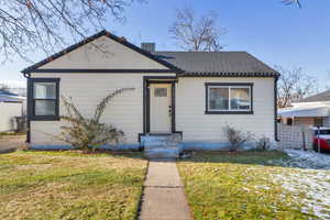 Bungalow-style house with a front lawn, a shingled roof, and board and batten siding