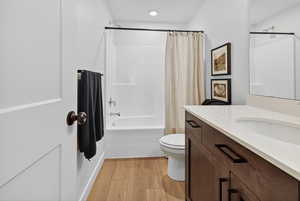 Full bathroom featuring vanity, shower / bath combination with curtain, and light wood finished floors