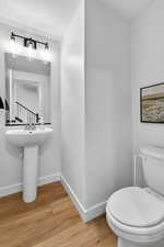 Half bathroom featuring light wood finished floors and baseboards