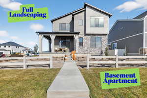 View of front facade featuring a porch and stone siding