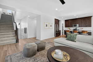 Living area with stairs, recessed lighting, and light wood-style floors