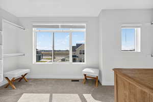 Living area featuring light colored carpet and baseboards