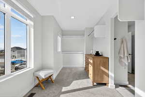 Spacious closet with light carpet