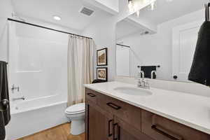 Full bathroom featuring shower / bath combo with shower curtain, vanity, light wood-style floors, and recessed lighting
