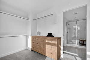 Spacious closet featuring light marble finish floors