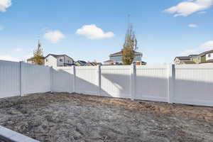 Fenced backyard featuring a residential view