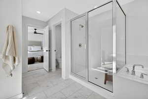 Bathroom with a bath, connected bathroom, a shower stall, light marble finish floors, and recessed lighting