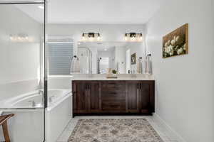 Full bath with a bath, double vanity, and a shower stall