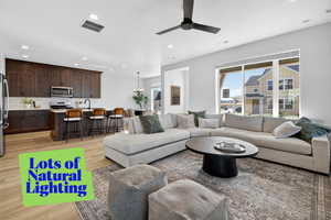 Living area featuring light wood-style floors, recessed lighting, a ceiling fan, and a chandelier