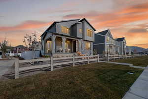 View of front of house with a fenced front yard, a porch, stone siding, and a residential view