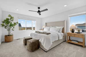 Carpeted bedroom with multiple windows, ceiling fan, recessed lighting, and a water view