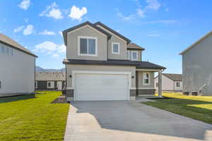 View of front of home featuring a front lawn, an attached garage, stucco siding, and concrete driveway