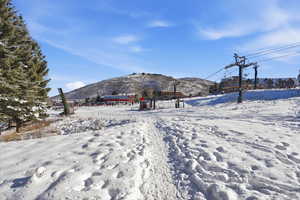 Yard covered in snow featuring a mountain view