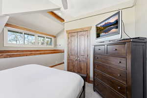 Bedroom featuring vaulted ceiling, a closet, a ceiling fan, and carpet