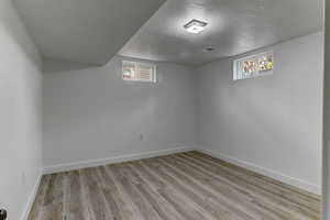 Bedroom room featuring a textured ceiling, light wood-style floors, and healthy amount of natural light