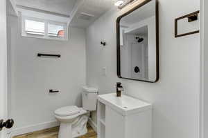 Full bath with wood finished floors, a textured ceiling, and vanity