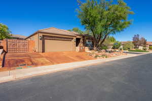 Ranch-style home with a gate, a garage, driveway, stucco siding, and a tile roof